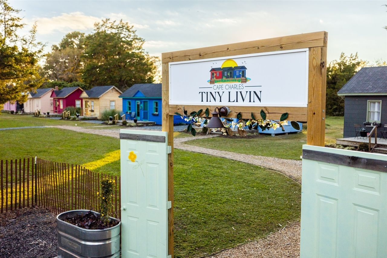 A sign that says tiny livin is in front of a row of small houses.