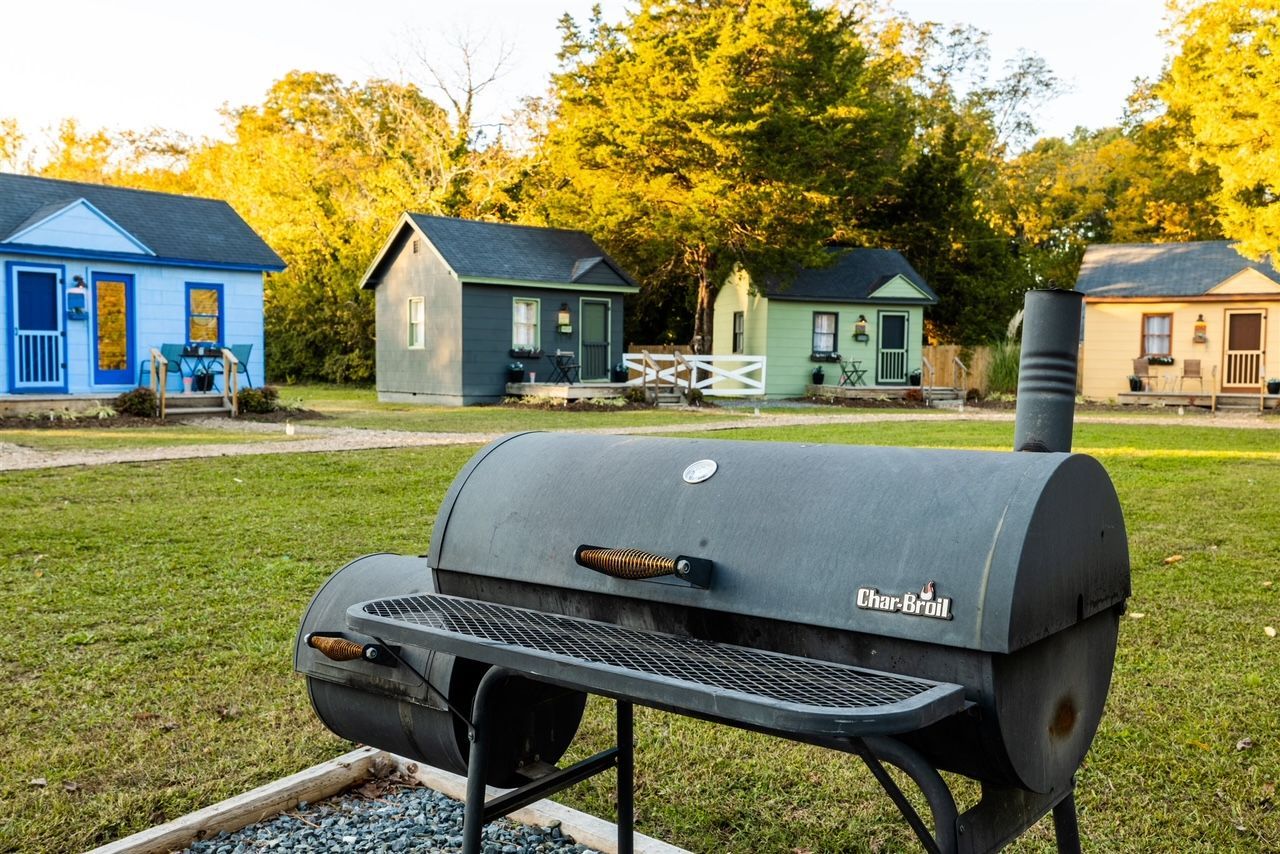 a barbecue grill is sitting in front of a row of small houses .