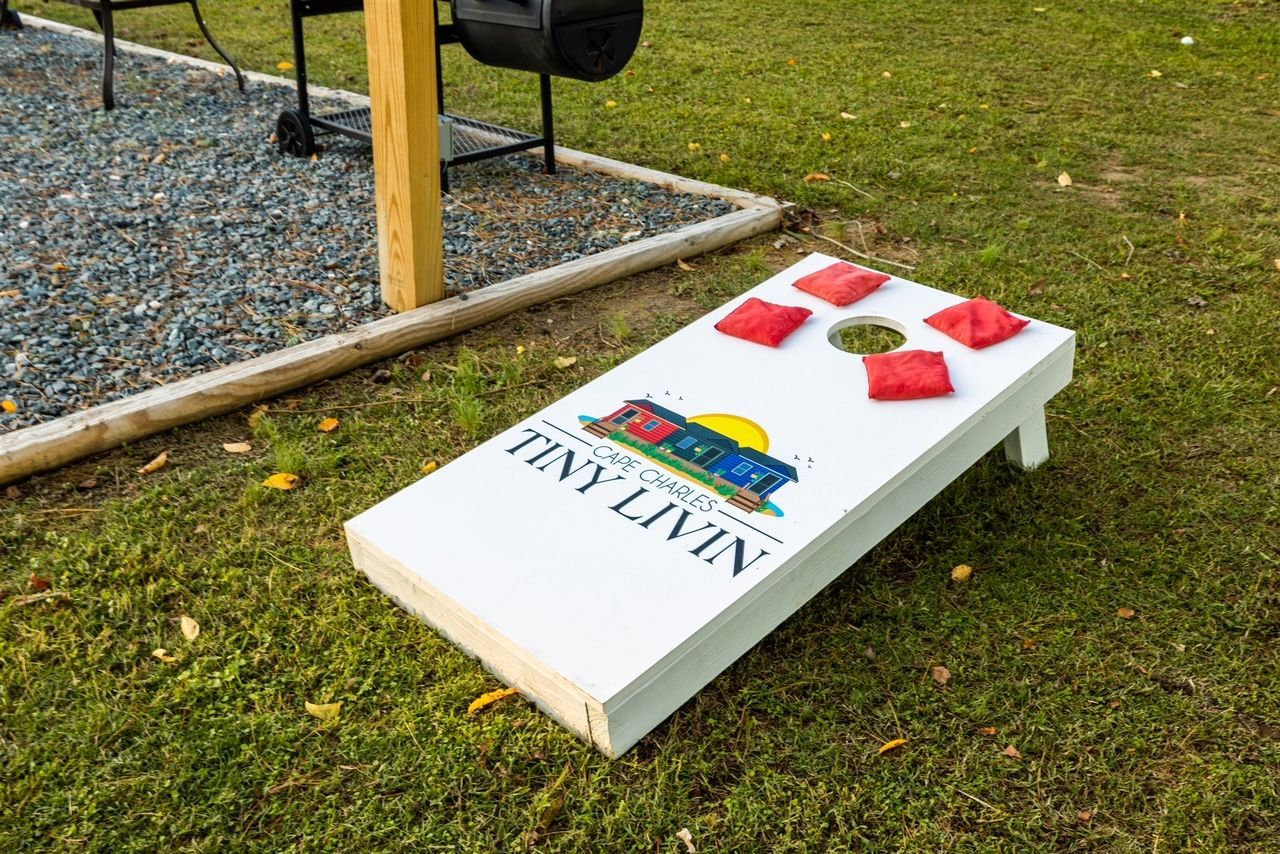 a cornhole board is sitting on top of a lush green field .