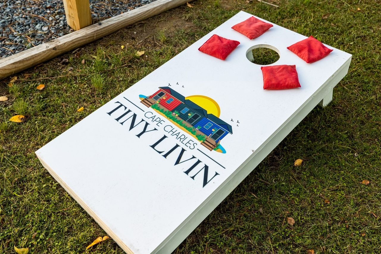 a cornhole board is sitting on top of a lush green field .