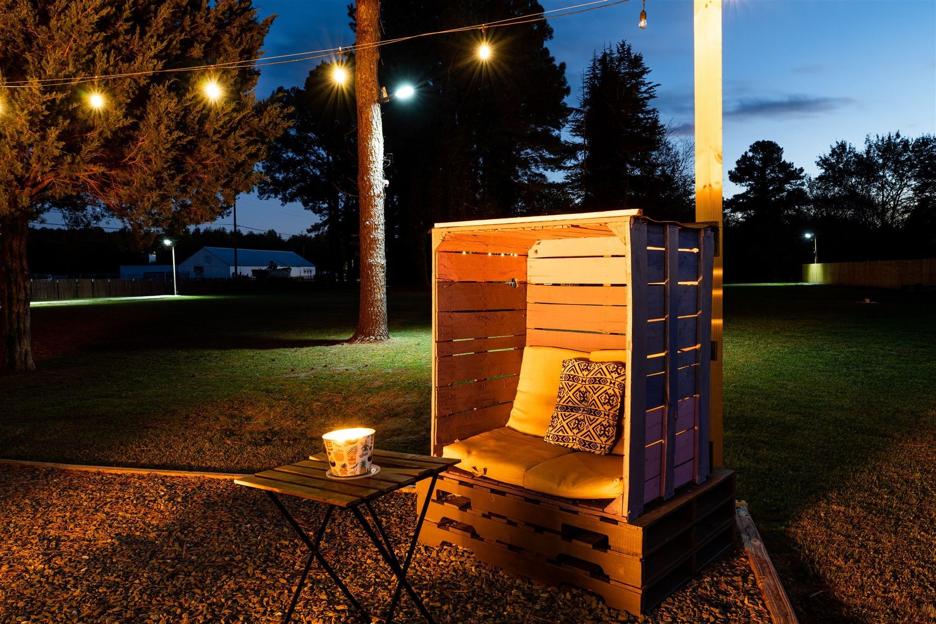 a chair made out of wooden crates is lit up at night