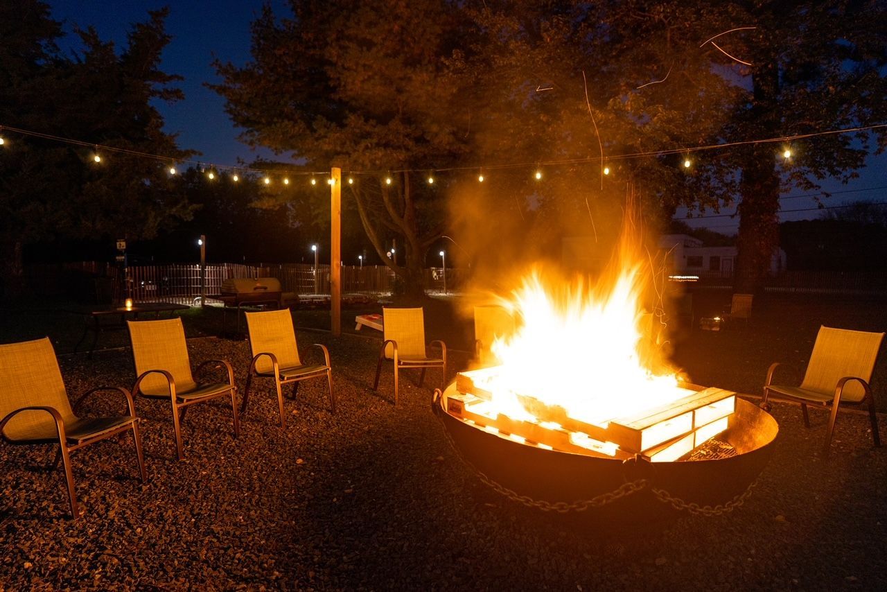 a fire pit with chairs around it at night .