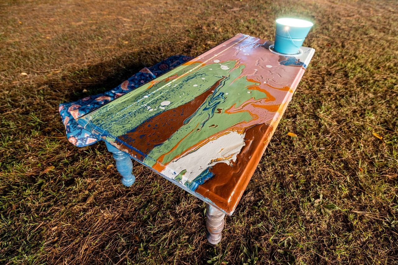 a colorful table is sitting on top of a lush green field .