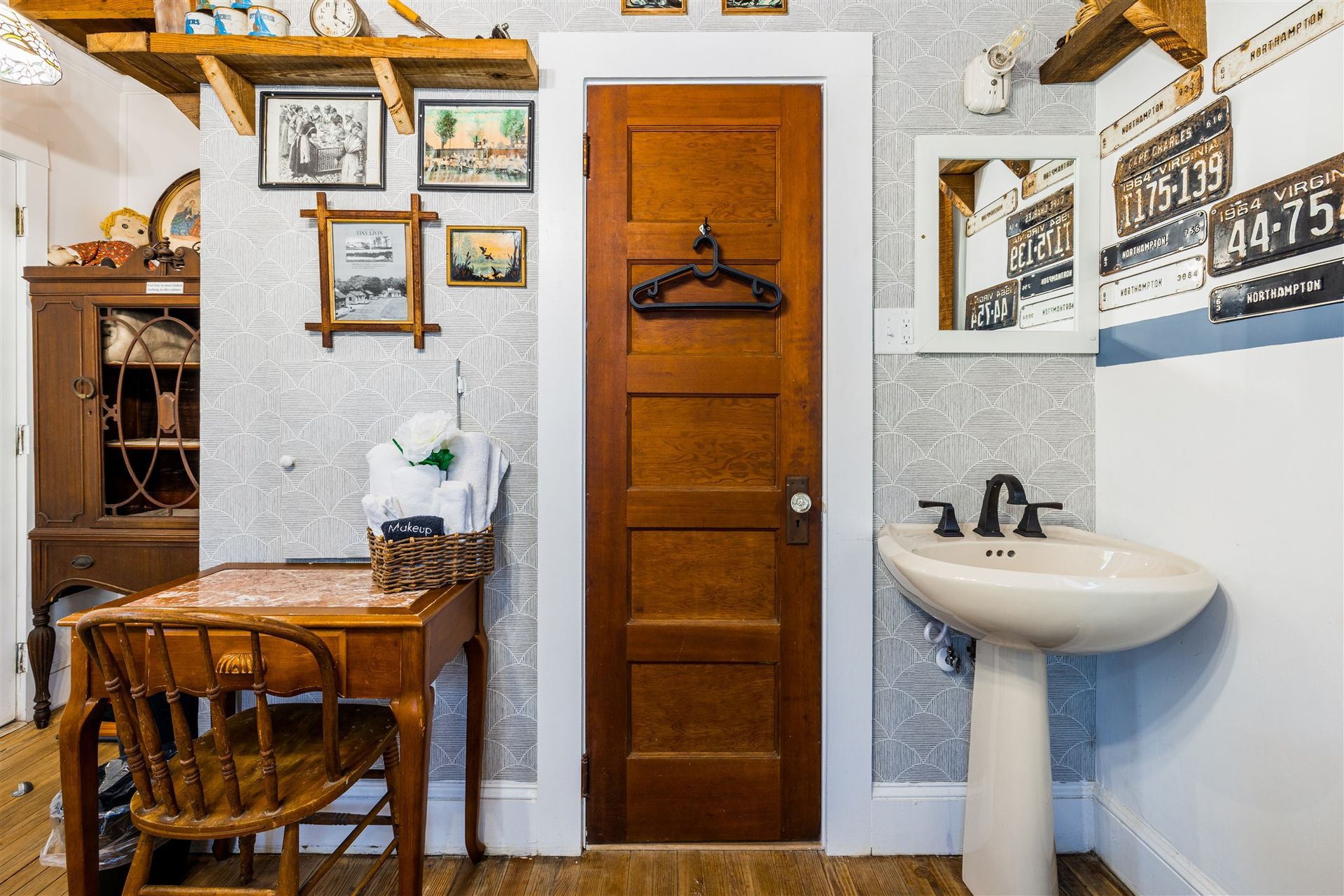 a bathroom with a sink , desk , chair and mirror .