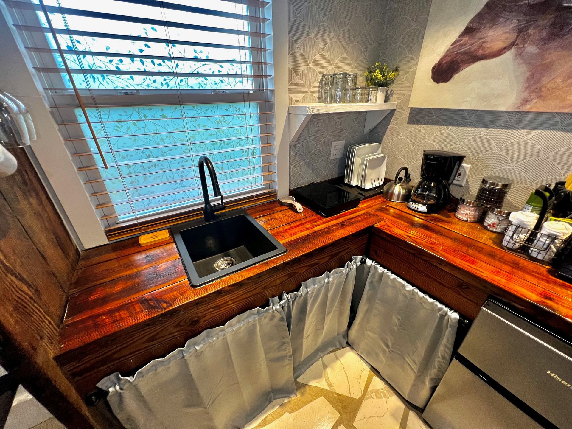 a kitchen with a sink and a picture of a horse on the wall .