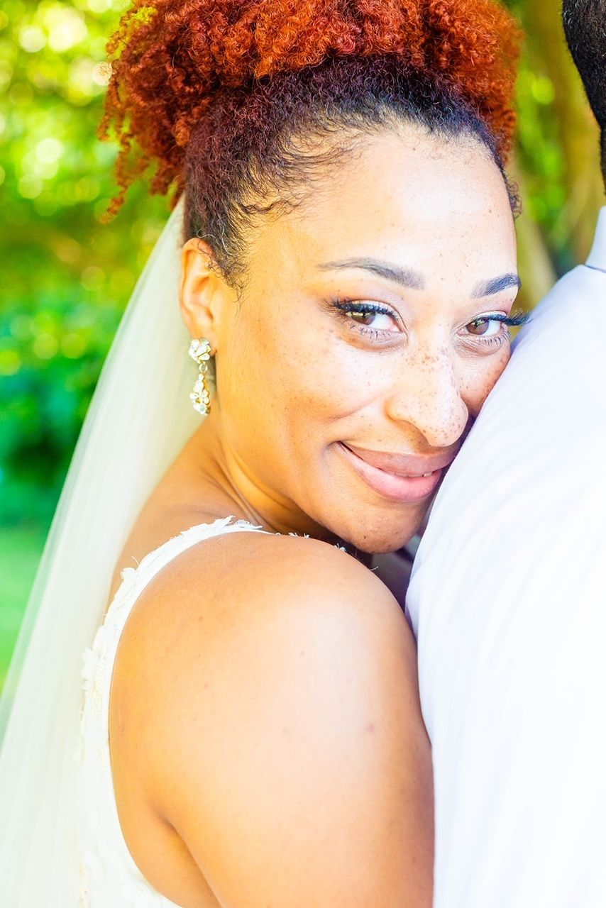 a woman in a wedding dress is hugging a man in a white shirt .