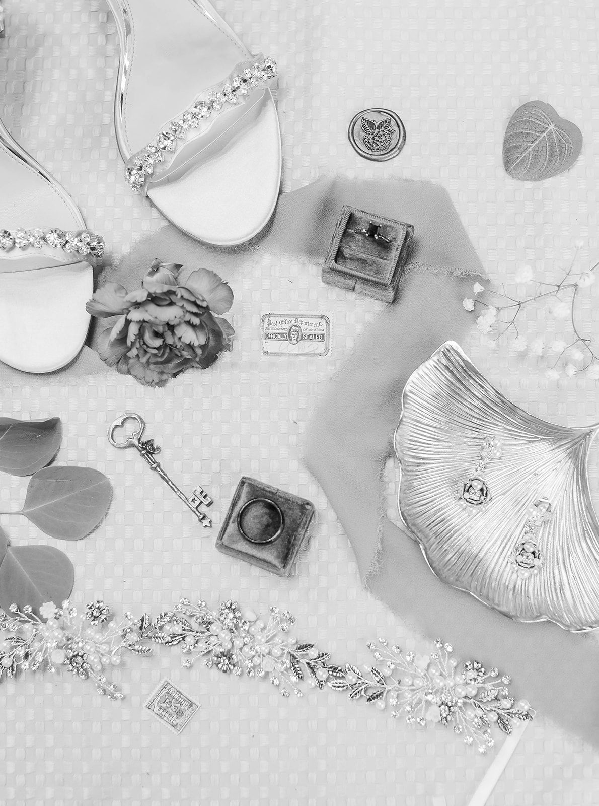 a black and white photo of a bride 's wedding shoes and jewelry .