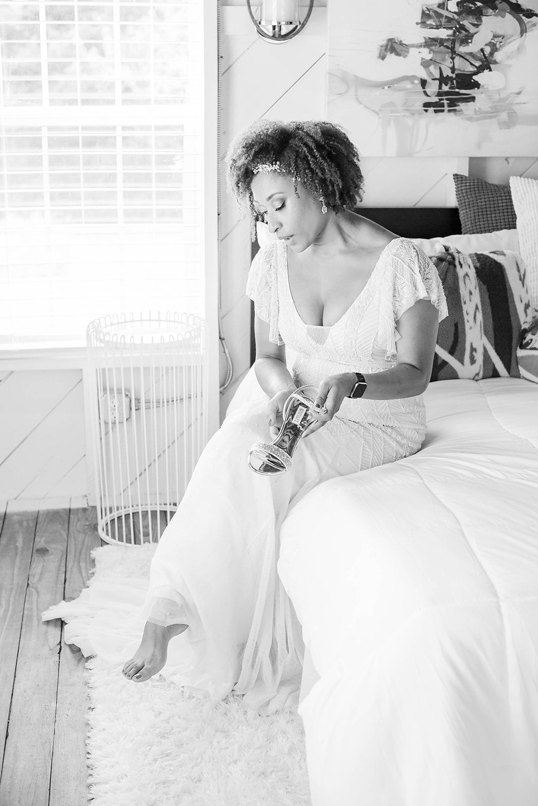 a woman in a wedding dress is sitting on a bed .