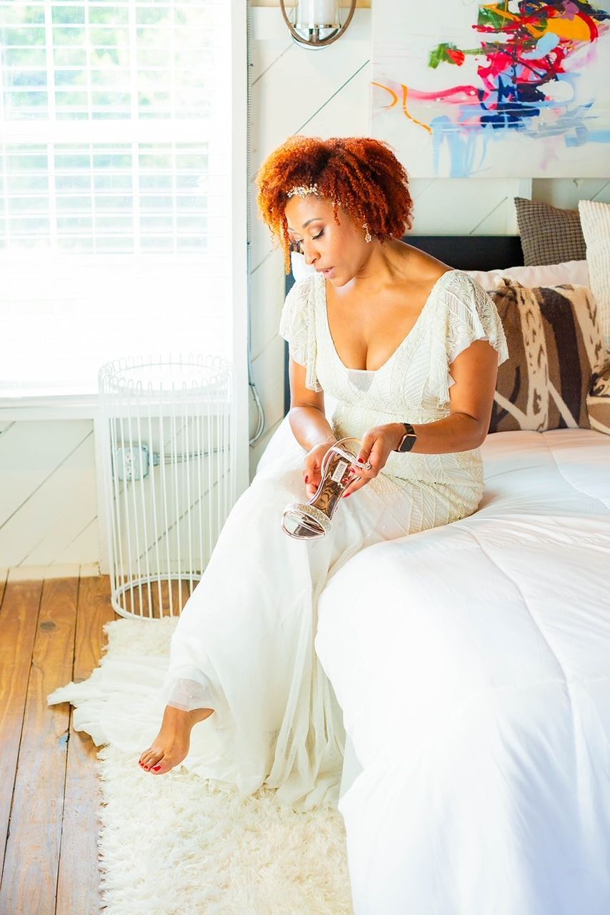 a woman in a white dress is sitting on a bed .