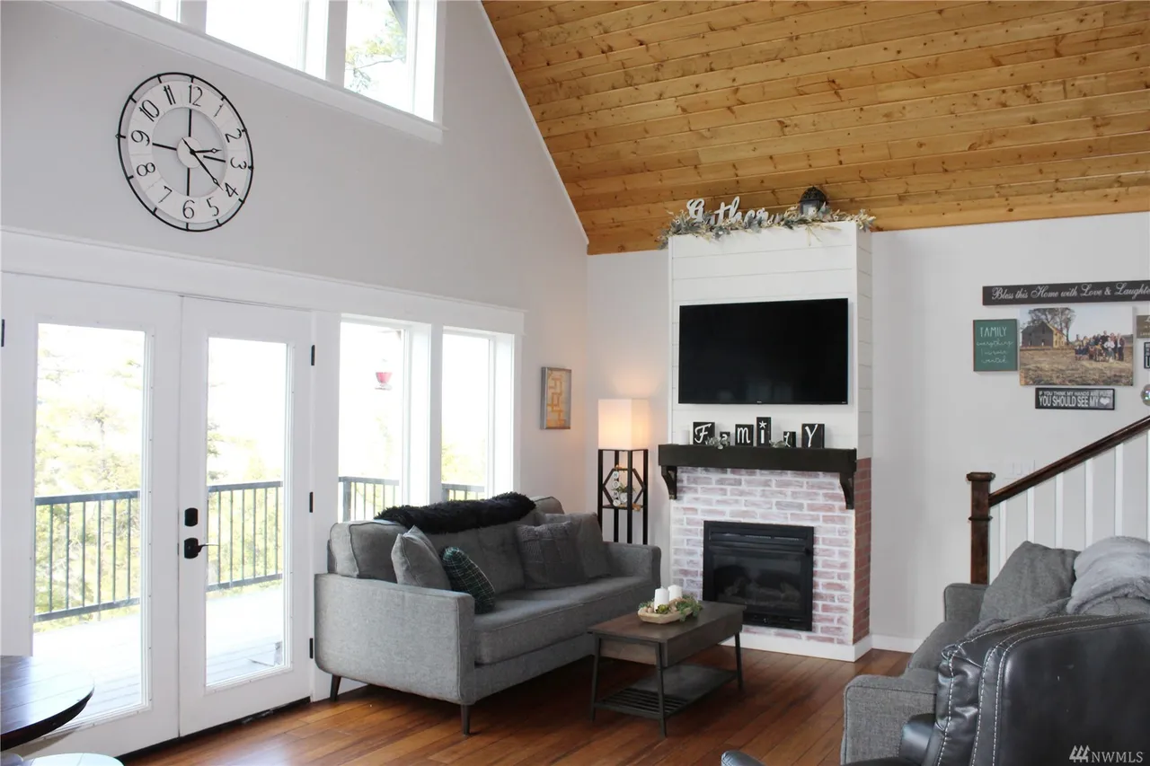 Green shed with white trim and doors on a paved patio.