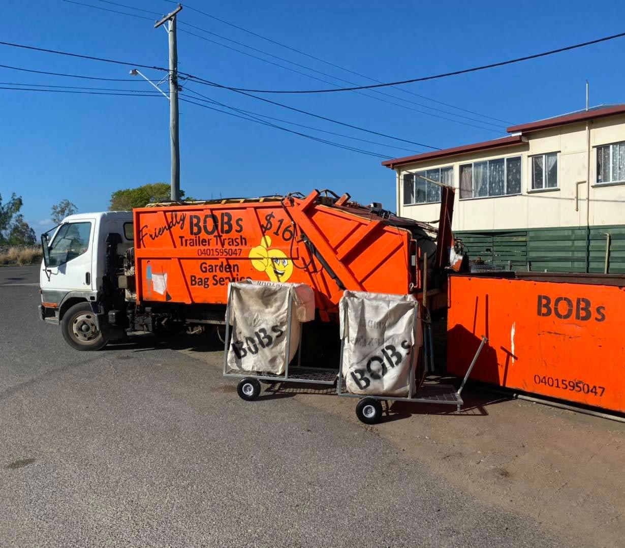 Truck Loading a Full Skip Waste Management Container — Rubbish Removal in Rockhampton, QLD