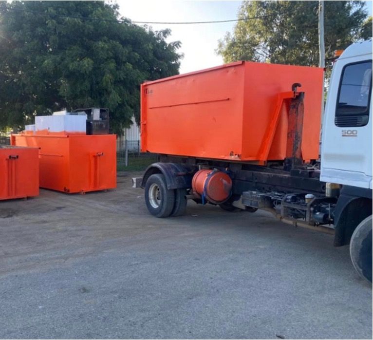 Red Garbage Bins Near New Office Building — Rubbish Removal in Rockhampton, QLD