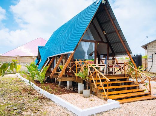 A small house with a blue roof and wooden stairs
