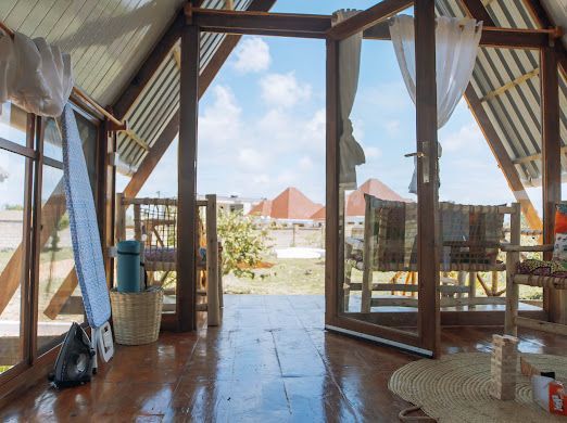 A room with a lot of windows and a surfboard on the floor