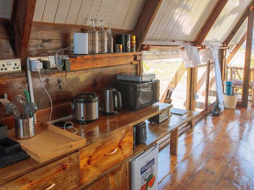 A kitchen with wooden cabinets and appliances including a microwave oven