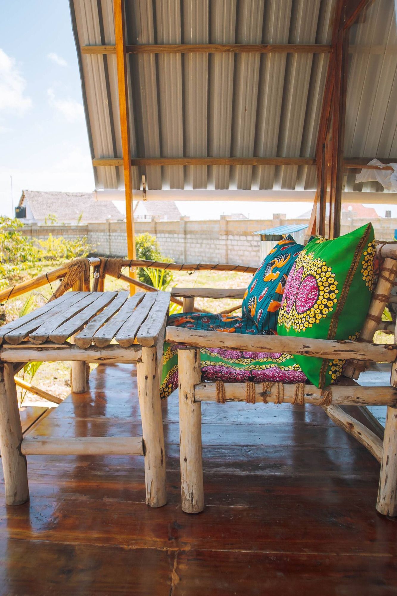 Two wooden chairs with pillows on them are sitting next to each other in front of a window.