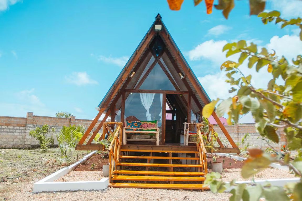 A small wooden house with stairs leading up to it.