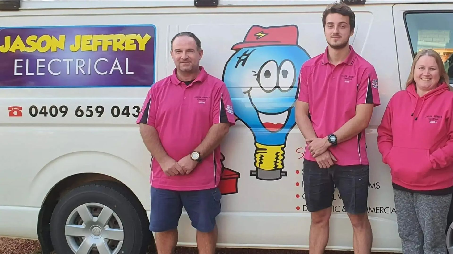 A Group of People Standing in Front of A Jason Jeffrey Electrical Van — Jason Jeffrey Electrical in South Tamworth, NSW