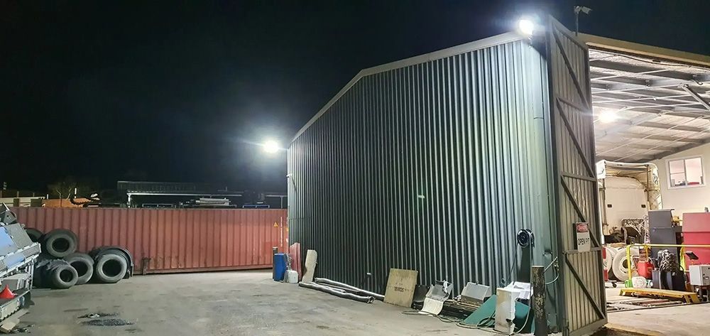 A Large Metal Building with A Lot of Tires in Front of It at Night — Jason Jeffrey Electrical in South Tamworth, NSW