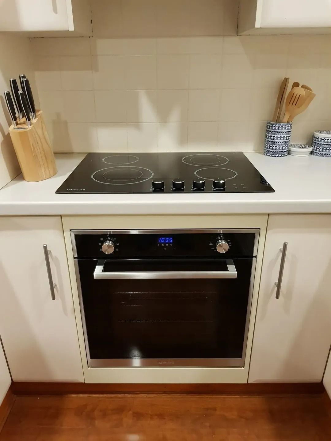 A Kitchen with A Black Stove Top Oven and White Cabinets — Jason Jeffrey Electrical in South Tamworth, NSW