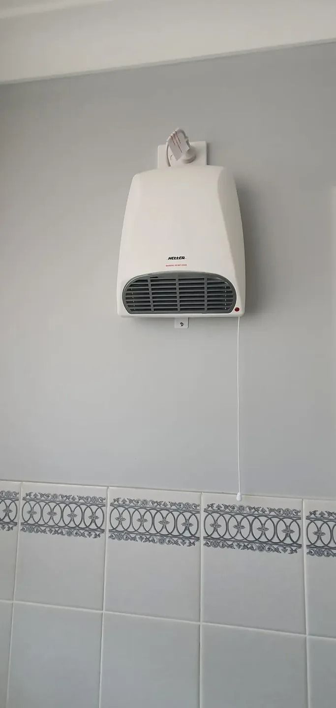 A White Fan Is Hanging on A Wall in A Bathroom — Jason Jeffrey Electrical in South Quirindi, NSW