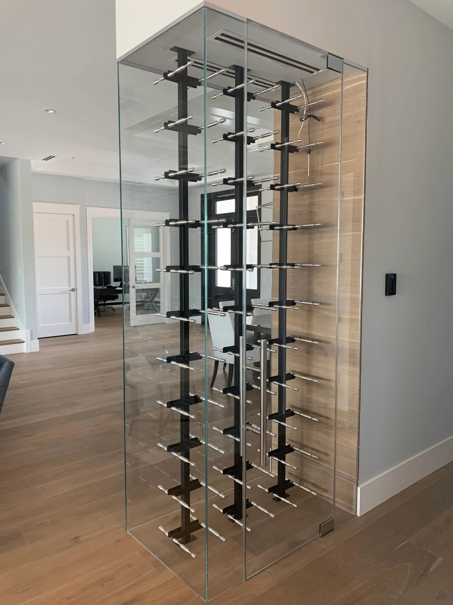 Clear acrylic wine rack in a modern room with a wood floor and white walls.
