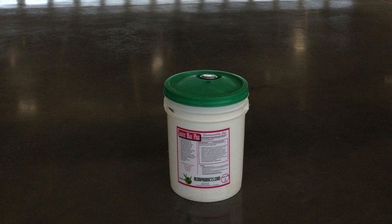 White bucket with a green lid on a reflective surface.