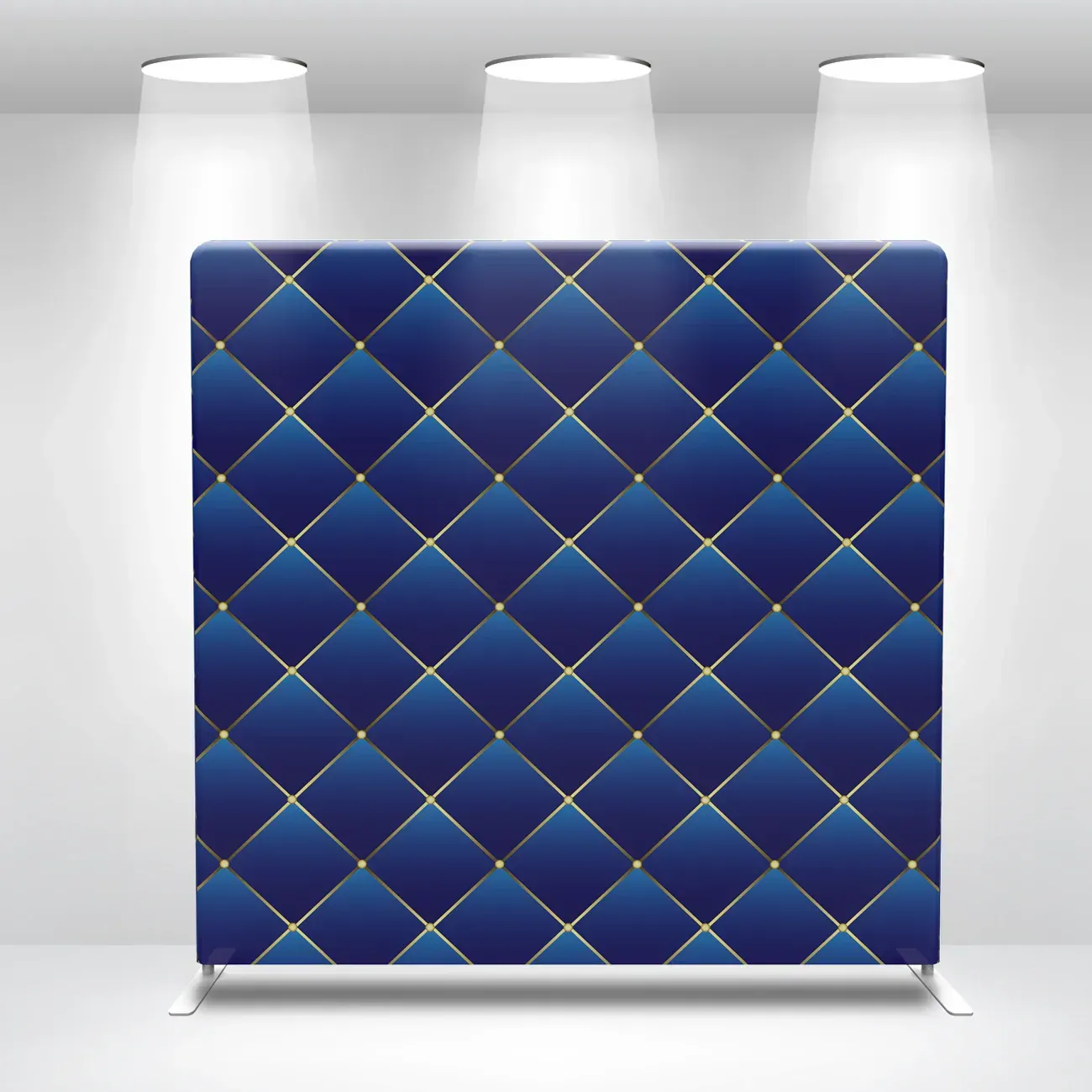 A blue and gold quilted backdrop is hanging on a wall.