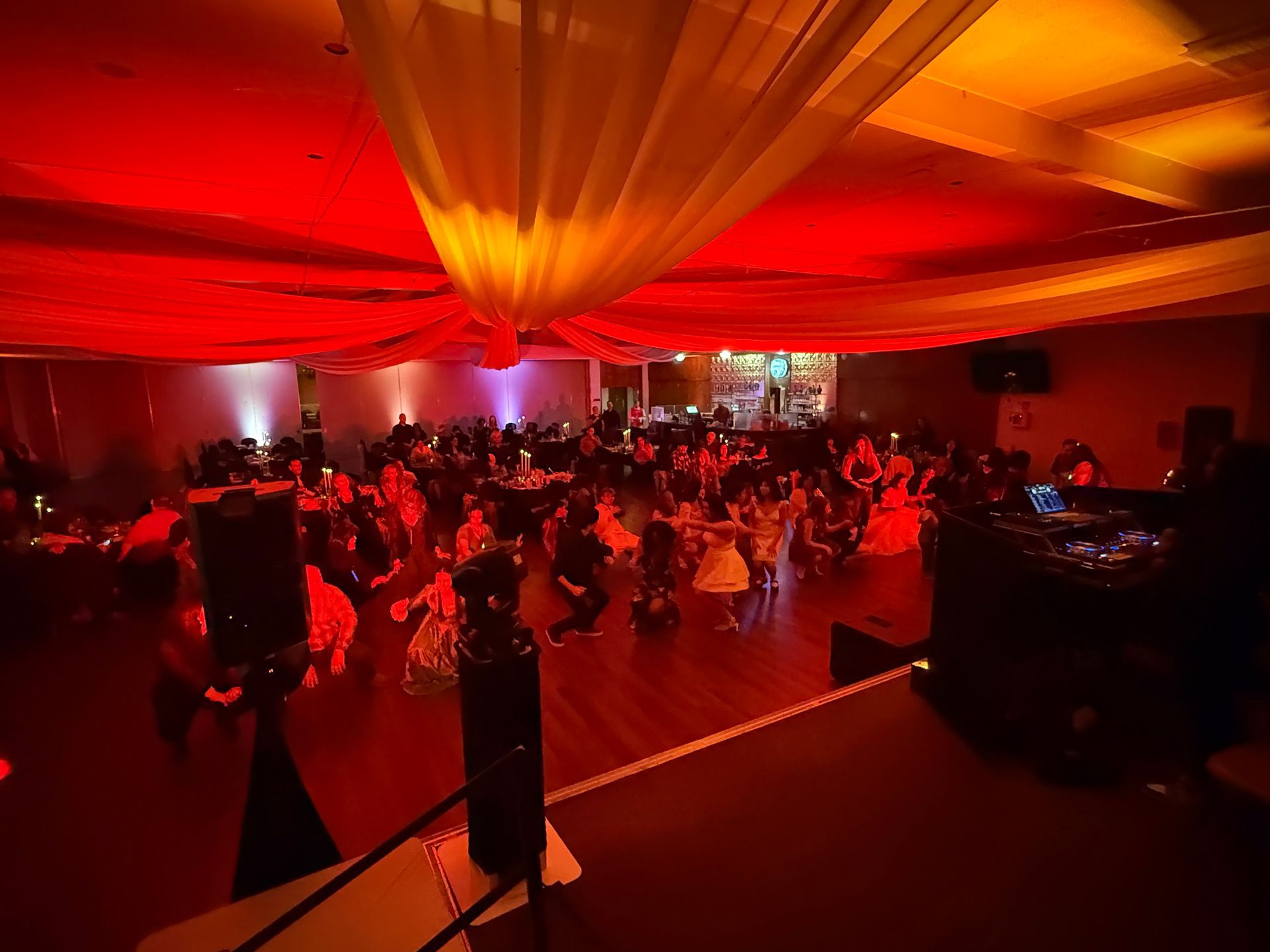 A large room filled with people dancing and sitting at tables.