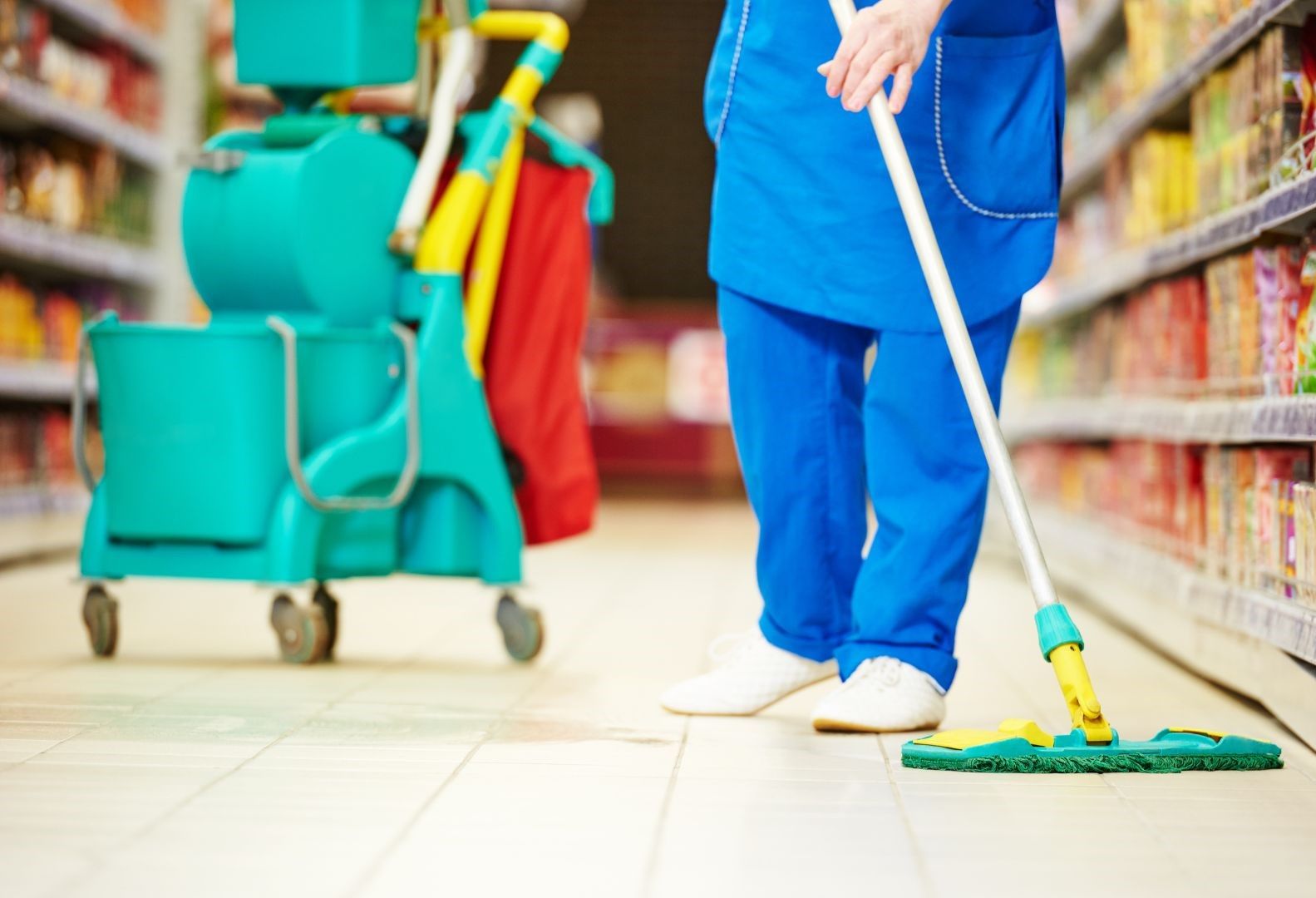 A person is mopping the floor of a store with a mop.