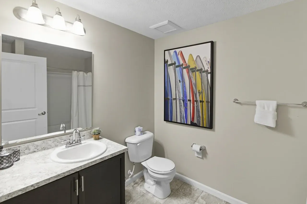 Modern bathroom with vanity, toilet, and shower.