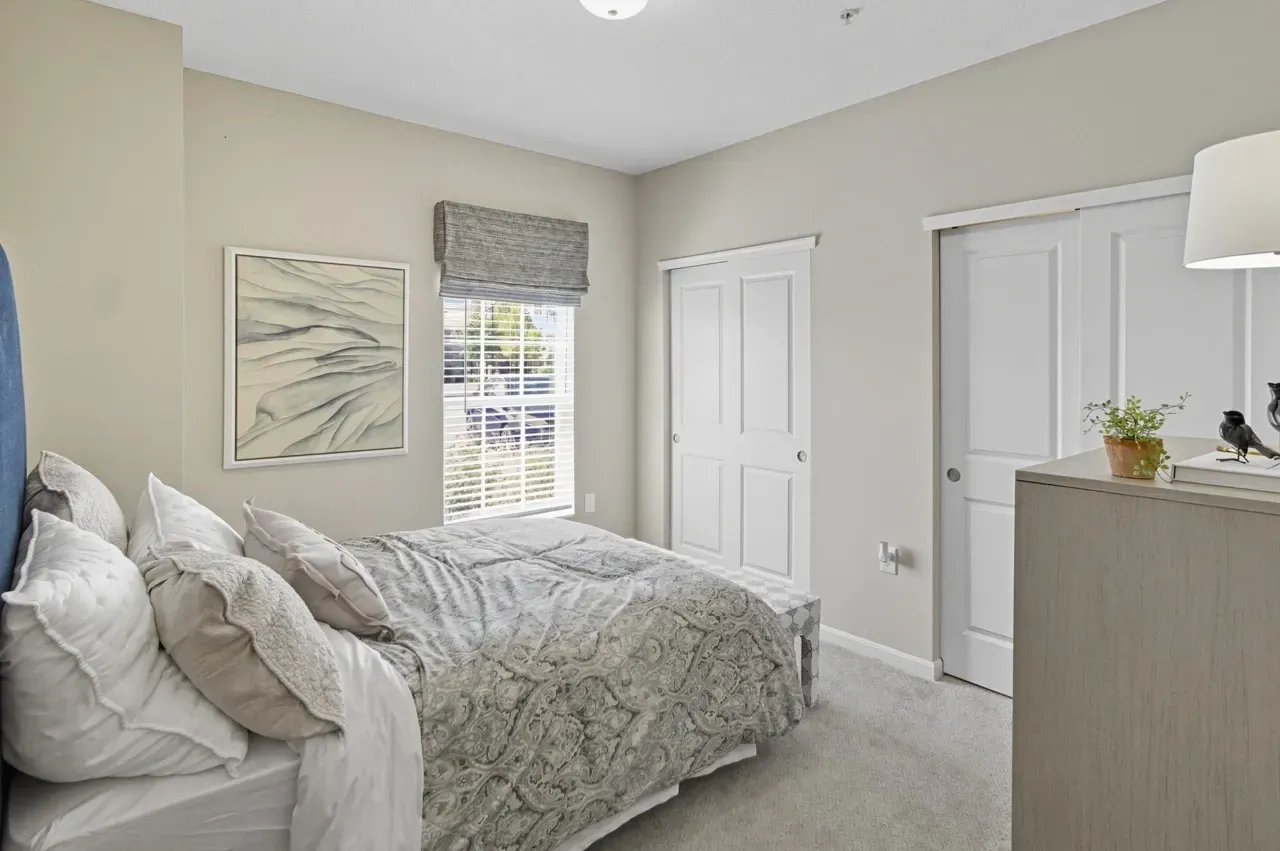A cozy bedroom featuring a large bed with plush pillows and a decorative throw.