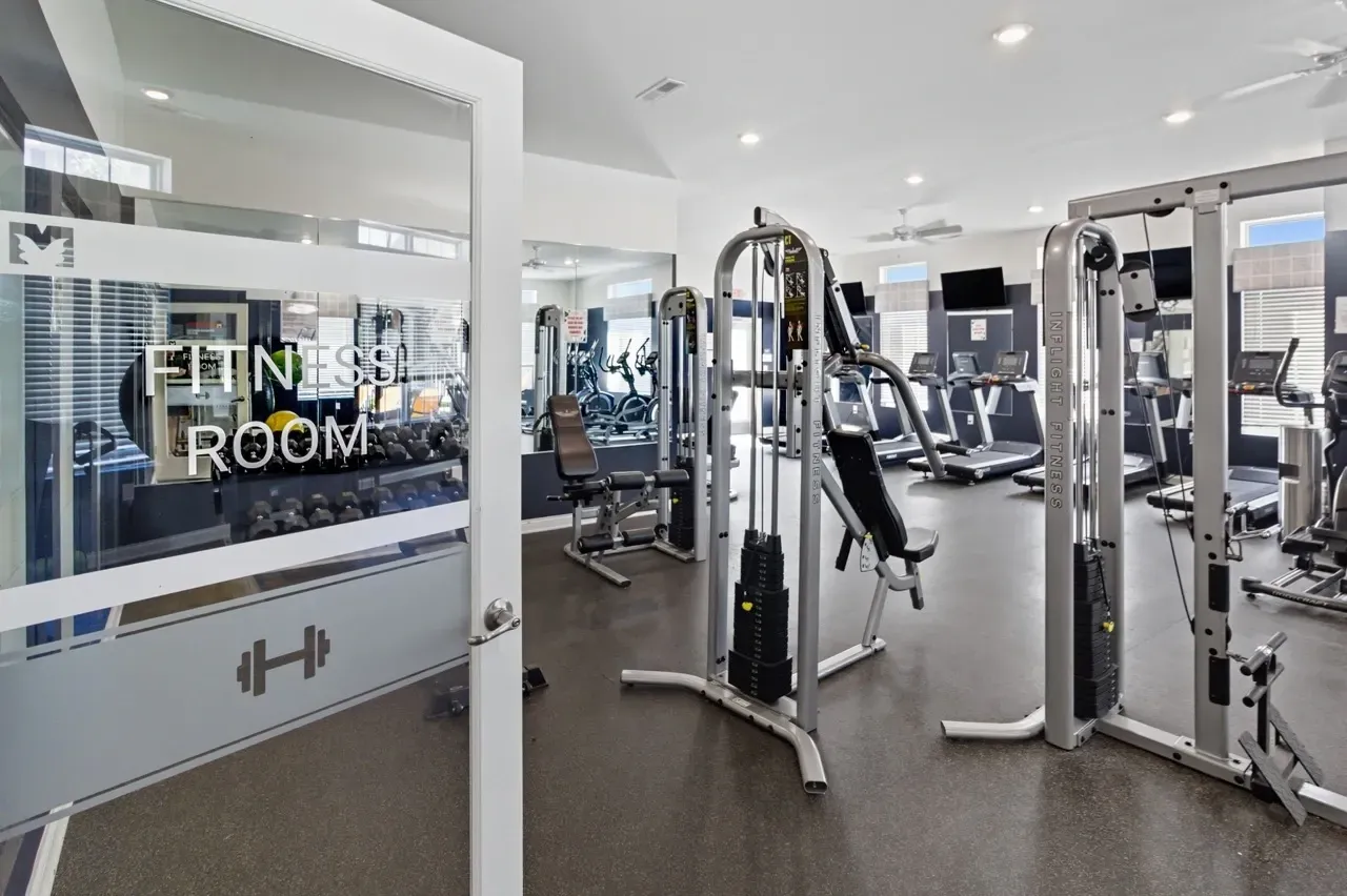 Fitness room with cardio machines and free weights.