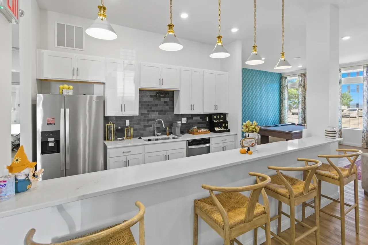 Kitchenette with bar seating and pool table in background