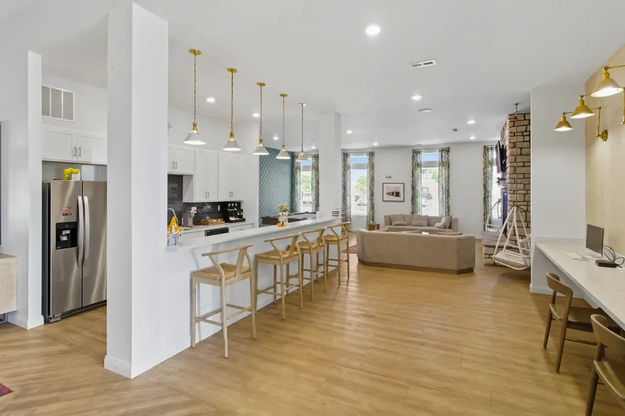 Community lounge area with kitchen, seating, and a billiards table.