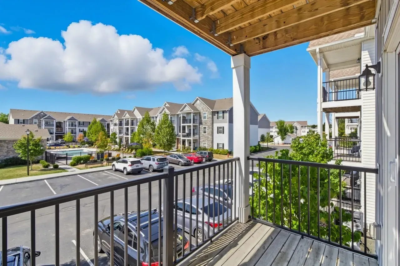 View from balcony overlooking a swimming pool and apartment buildings.