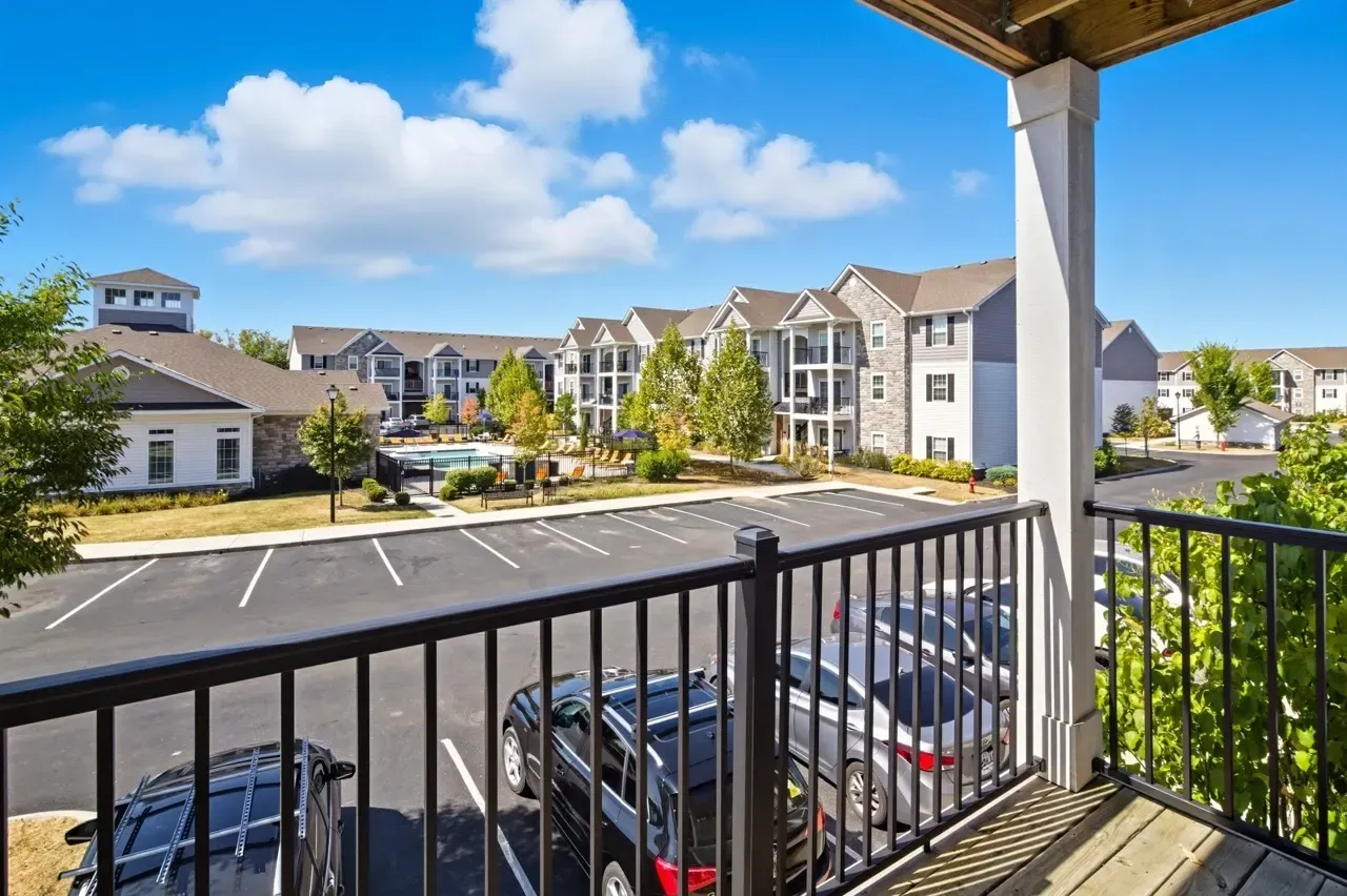 View of the community's outdoor pool and surrounding apartment buildings from a balcony.