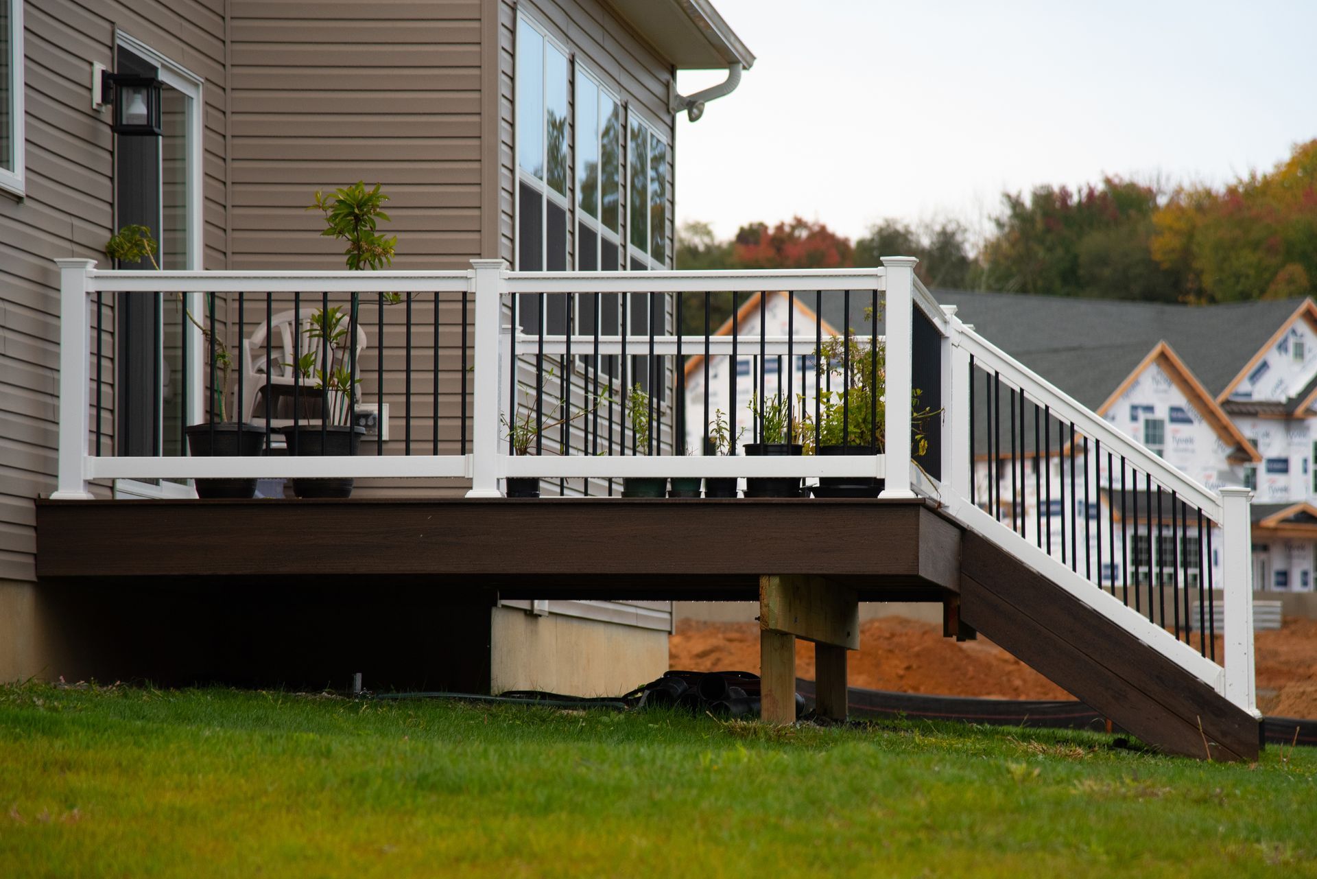 A deck with stairs leading up to it is in front of a house.