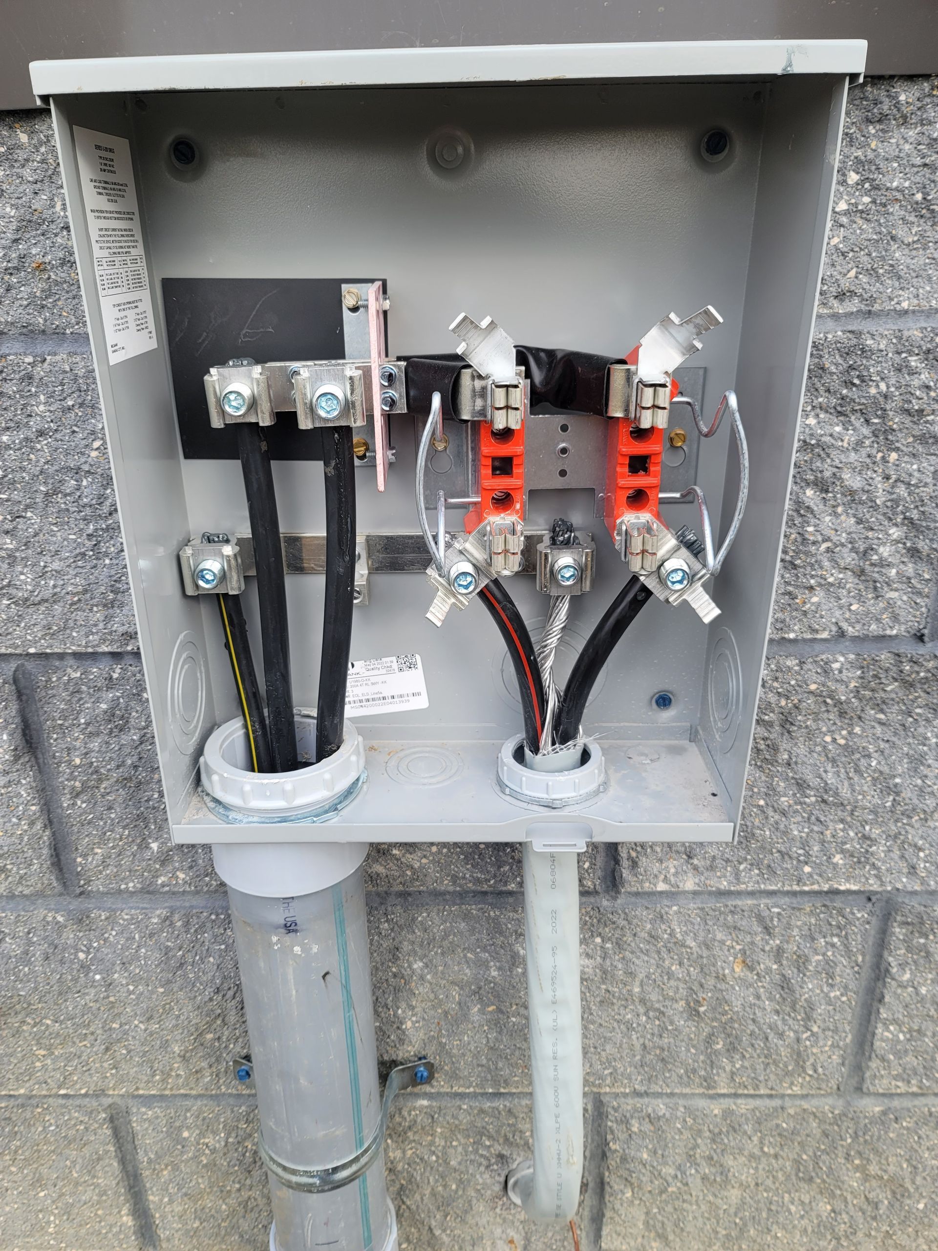 Electrical box with black, red, and white wires connecting to terminals inside a grey enclosure.