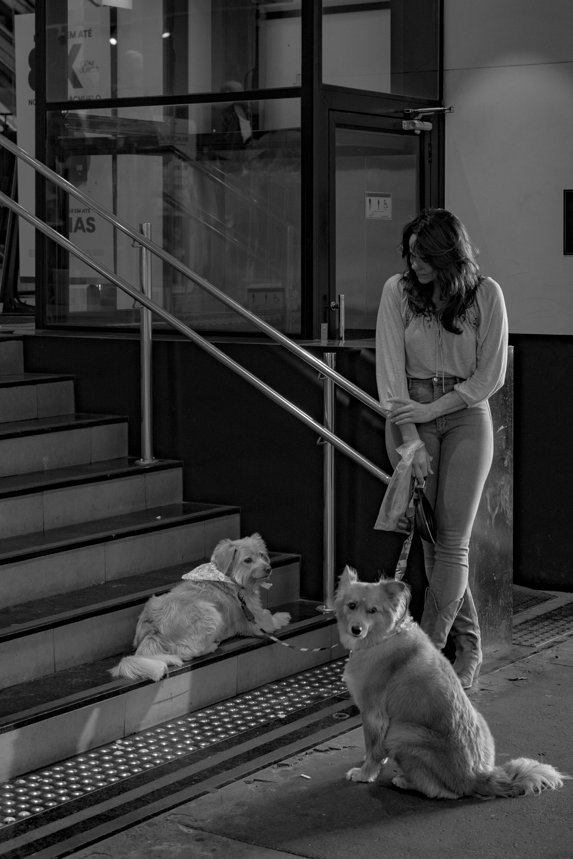 A black car is parked in a parking lot in front of a building.
