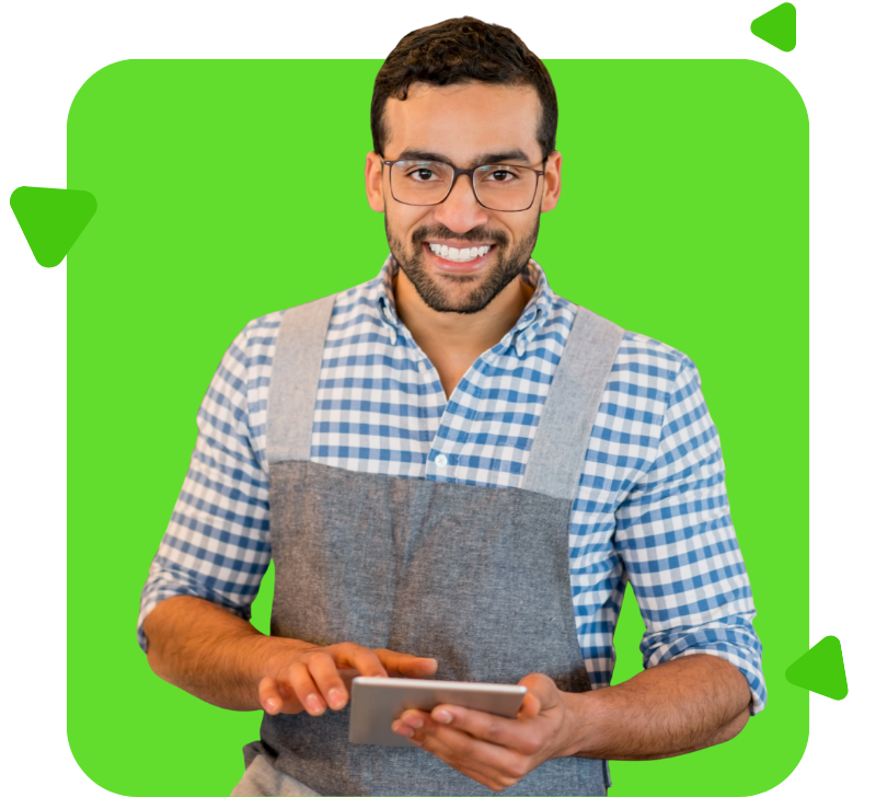 Una mujer sostiene una tableta y sonríe frente a un fondo verde.