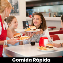 Un grupo de personas están sentadas en una mesa comiendo hamburguesas y papas fritas. - Vendty Pos Restaurante