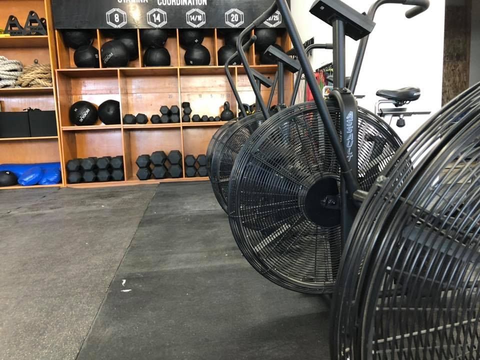 A row of exercise bikes are lined up in a gym