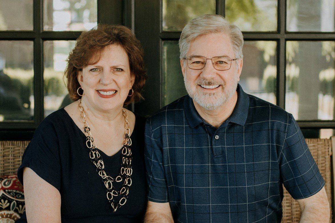 A man and a woman are sitting next to each other on a porch.