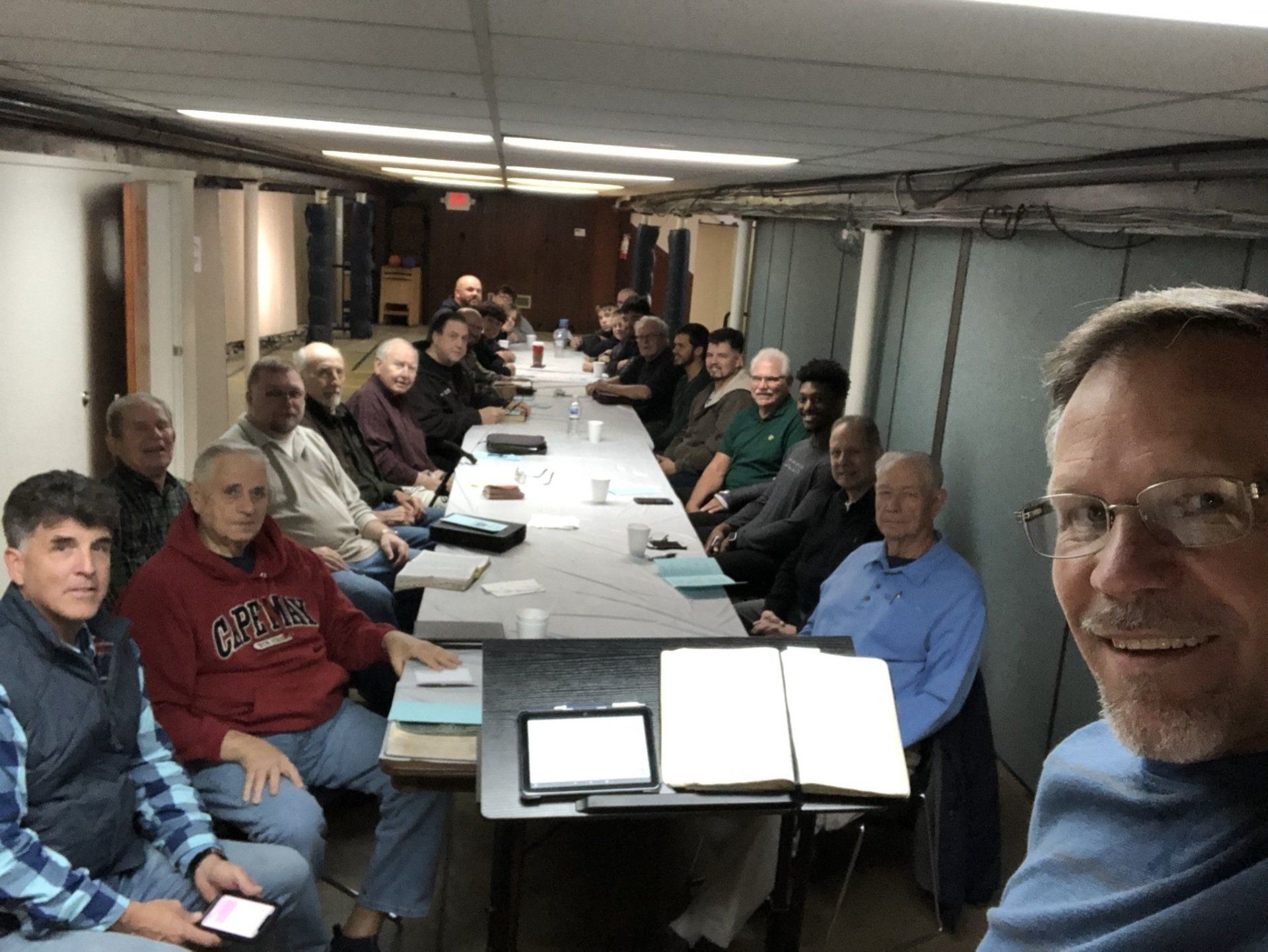 A group of men are sitting around a long table.