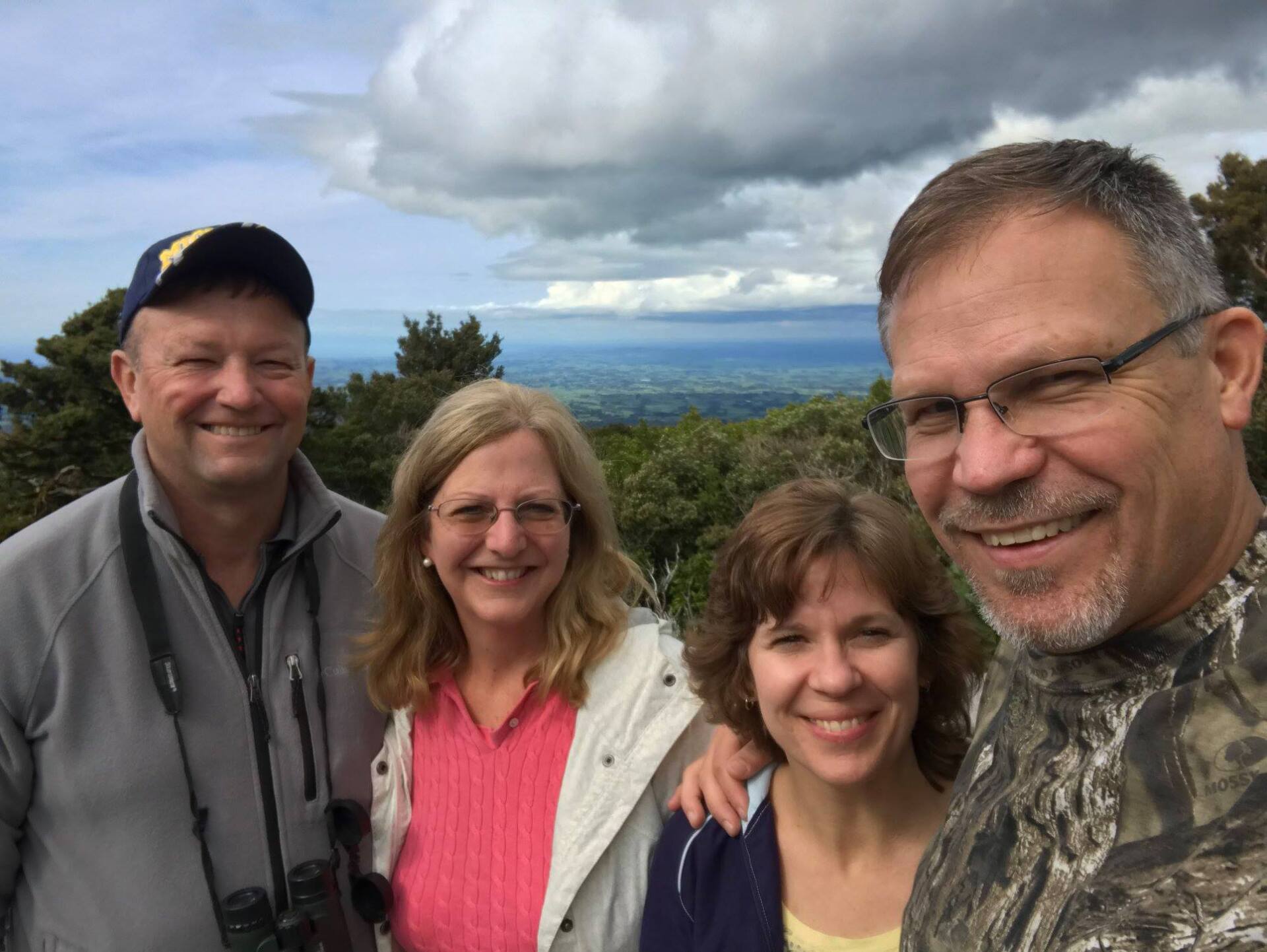 A group of people are posing for a picture on top of a mountain.