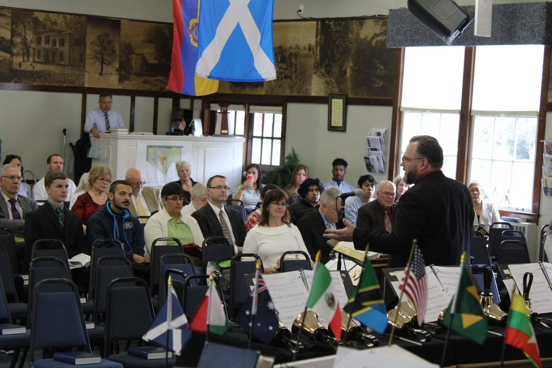 A man stands in front of a group of people sitting in chairs