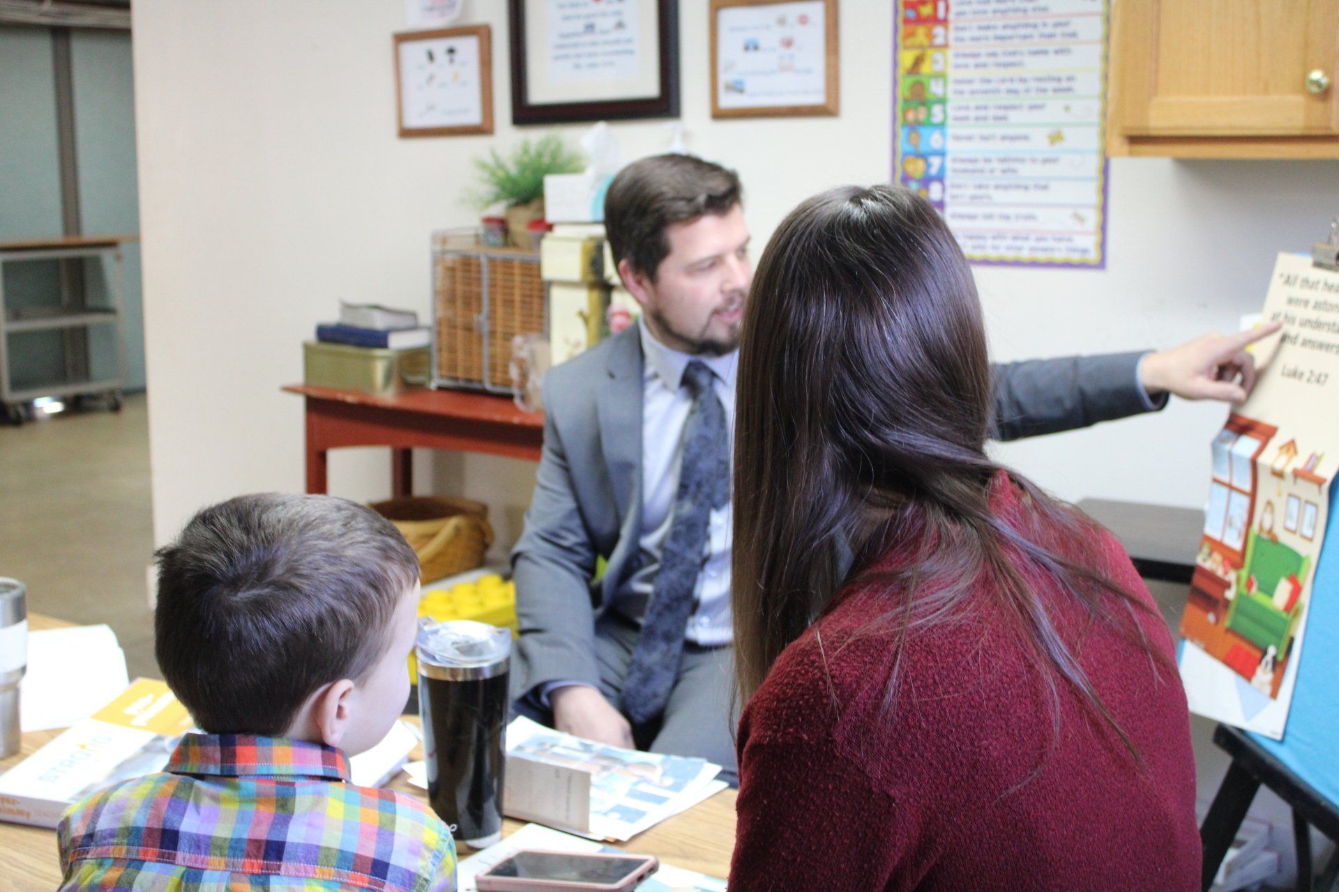 A man and a woman are sitting at a table with a child.