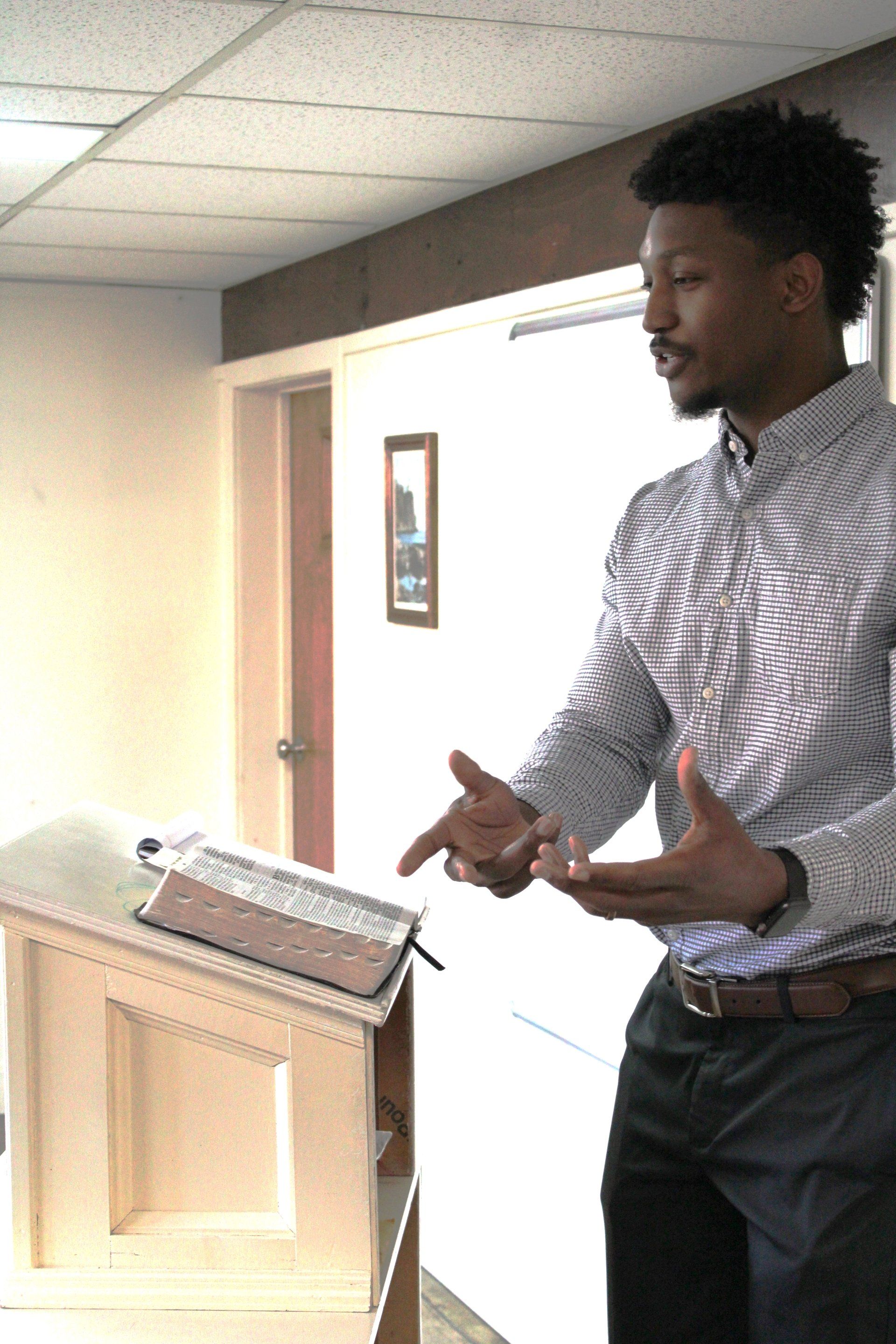 A man in a striped shirt is standing in front of a podiumbroke