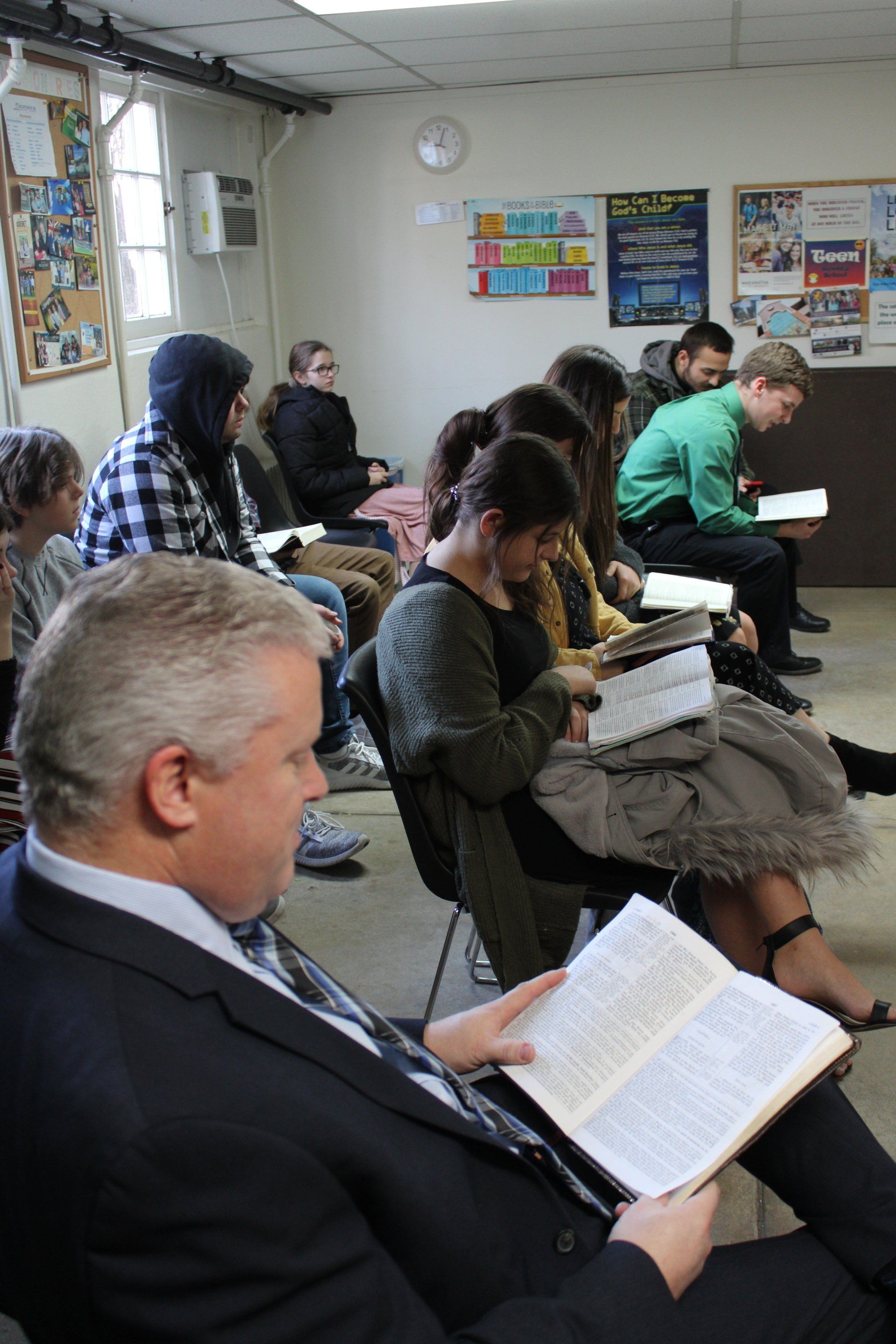 A group of people are sitting in a room reading books.